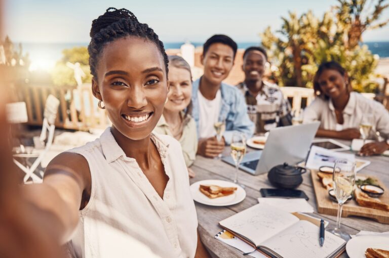 Brunch, selfie and friends at a beach restaurant after successful teamwork and business collaborati