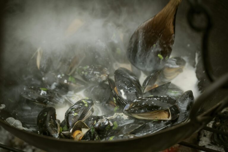 Chef cooking Black Mussels over a barbecue.